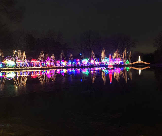 Spellbinding views of holiday lights reflecting in a still lake during the Holiday Light Show at Rotary Botanical Gardens,