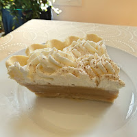 One slice of maple cream pie on a dessert plate on a tablecloth.