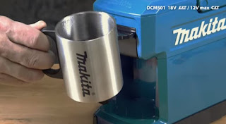A makita steel mug next to the Makita coffee machine