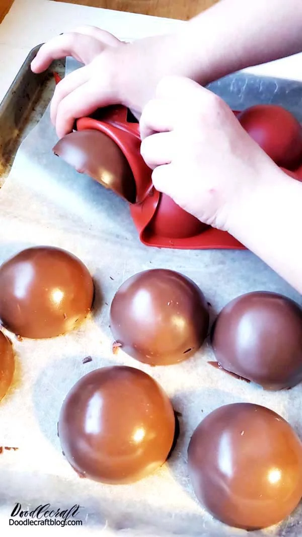 Step 3: Pop Out Bomb Shells Now that the chocolate is hardened, pop the shells out of the mold. Don't touch the chocolate with your fingers or it will leave fingerprints. Wear gloves.