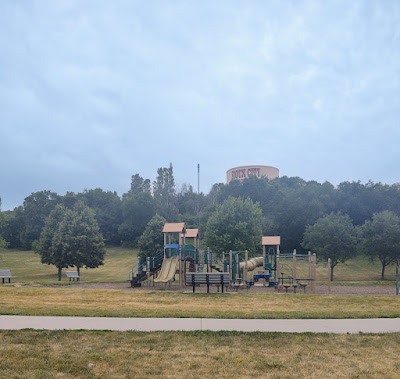 playground area, trees, and water tower at Sioux City's Sertoma Park