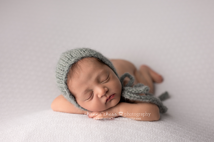 Eugene Oregon newborn photographer, baby in sage green cap asleep with head on hands