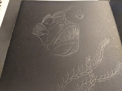 photo of pencil drawing of anglerfish on black paper
