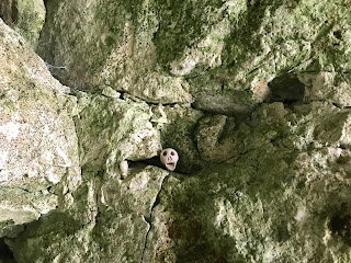 A close up photo of a small ceramic skull (Skulferatu 59) in the pitted. white chalk wall of the cave at Dumpton Bay by Dumpton Gap in Broadstairs.  Photo by Kevin Nosferatu for the Skulferatu Project.