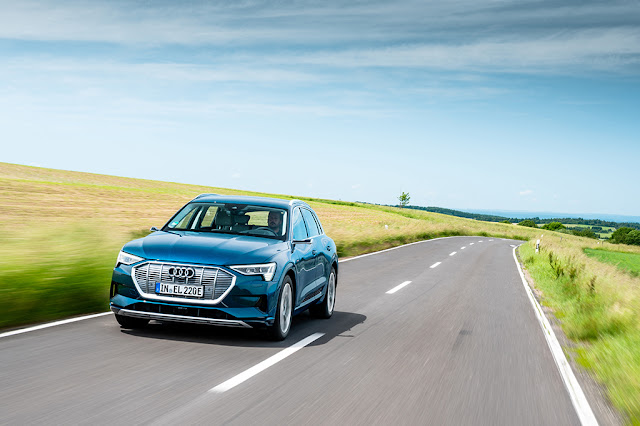 The Audi e-tron front view in the summer scenery.