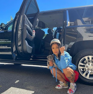 Coi Leray posing for picture while car in the background