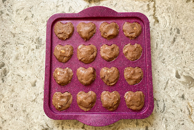 Filling the mini heart-shaped cupcake pan