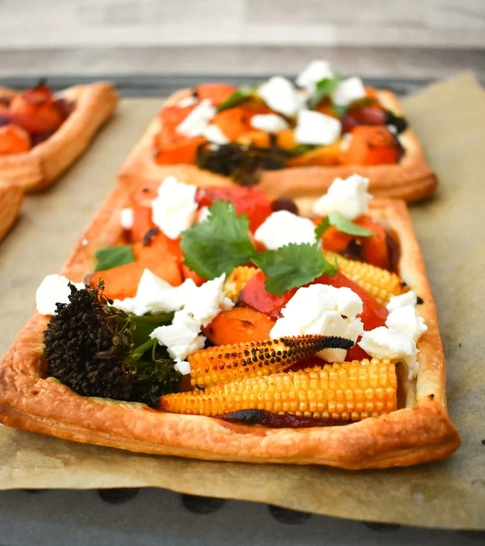 vegetable tarts on a baking sheet covered by greaseproof paper (baking paper)