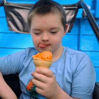 a boy sticks out his tongue in excitement at his orange ice cream come at Jason's Frozen Treats in Sioux City, Iowa