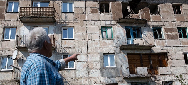 Un hombre frente a su casa dañada en el conflicto en el este de Ucrania. (Foto de archivo)© UNICEF/Aleksey Filippov