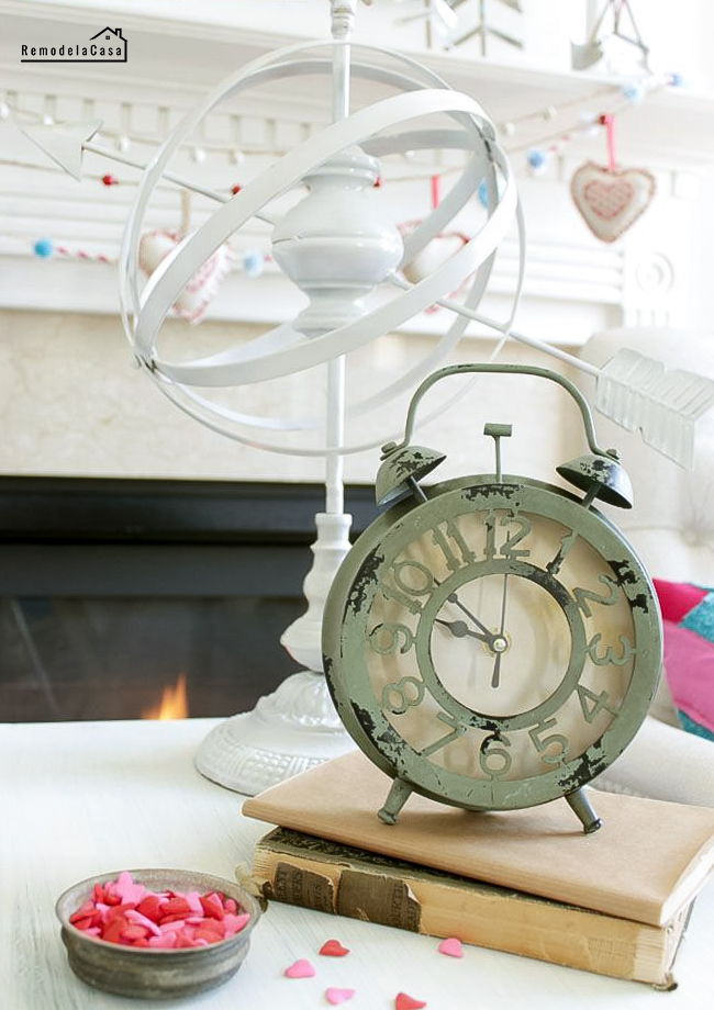 rustic clock and armillary sphere adorning a Valentines mantel