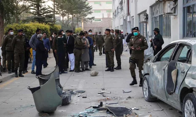 Security officials gather beside a damaged vehicle near the premises of a factory in Sialkot after police confirmed a Sri Lankan man was beaten to death. Photograph: AFP/Getty Images