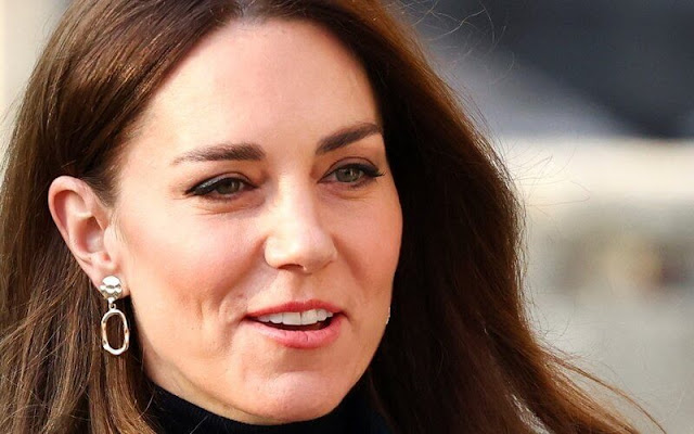 Kate Middleton wore her navy coat. Kate wore a sleek black polo neck top, and black trousers from Jigsaw. Accessorize gold earrings