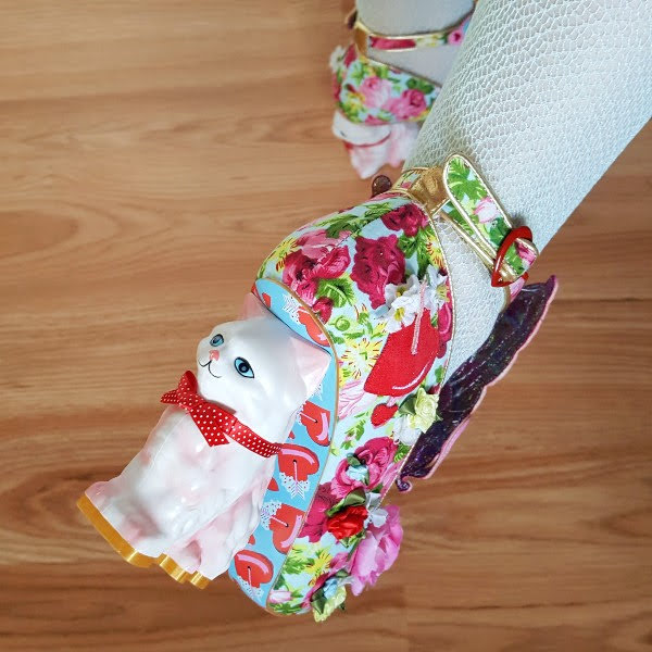 close up of foot with cat heel shoe in floral print