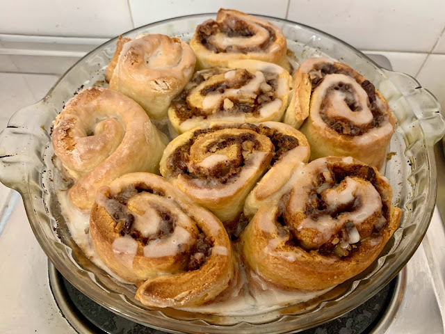 Round glass pan of glazed cinnamon rolls