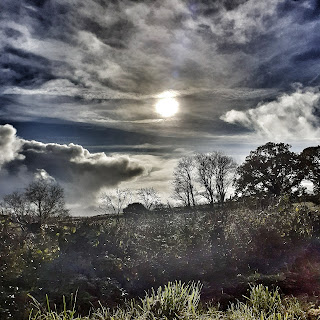 Winter sun shines through dramatic clouds, effect is uplifting