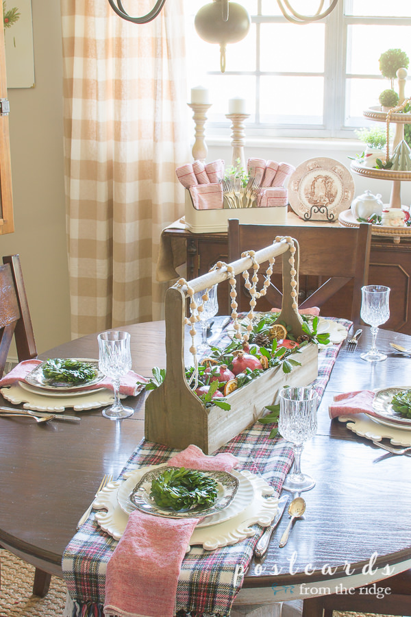 Christmas table decorated with plaid and natural items.