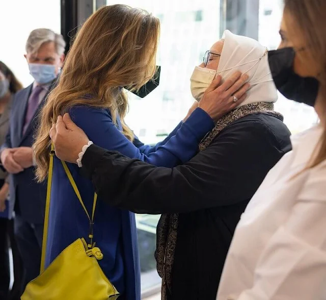 Queen Rania wore scarf collar silk tunic, and leather cropped wide-leg trousers by Loewe. Loewe lime-yellow bag