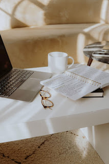 Workspace with laptop, eye glasses, notepad and coffee cup