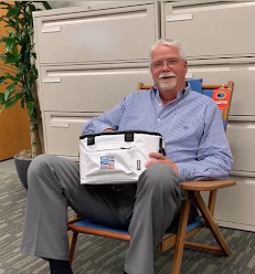 Man in beach chair drawing a name for a raffle prize