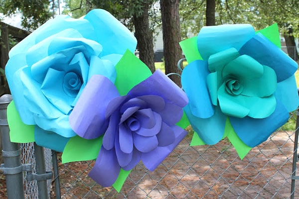 Make giant paper roses using astrobright paper and hot glue. Budget friendly crafts for big impact!