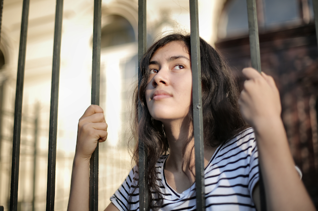 a woman behind a barrier preventing active communication