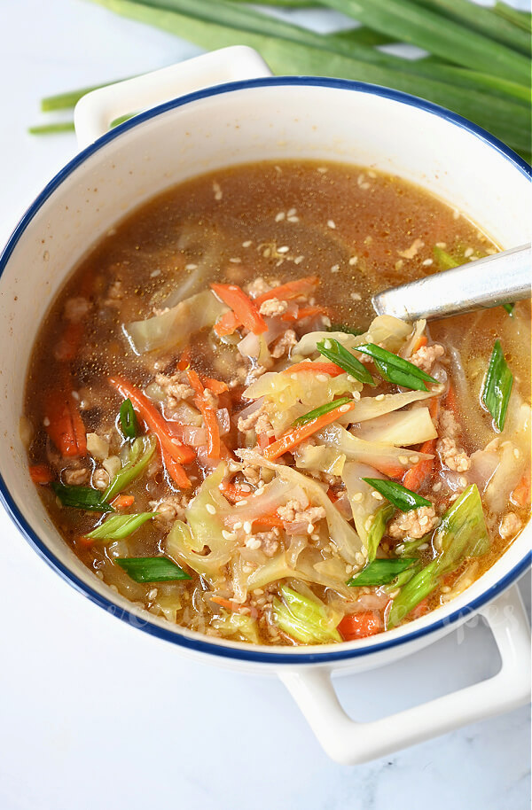 a close up of a white pot with easy egg roll soup