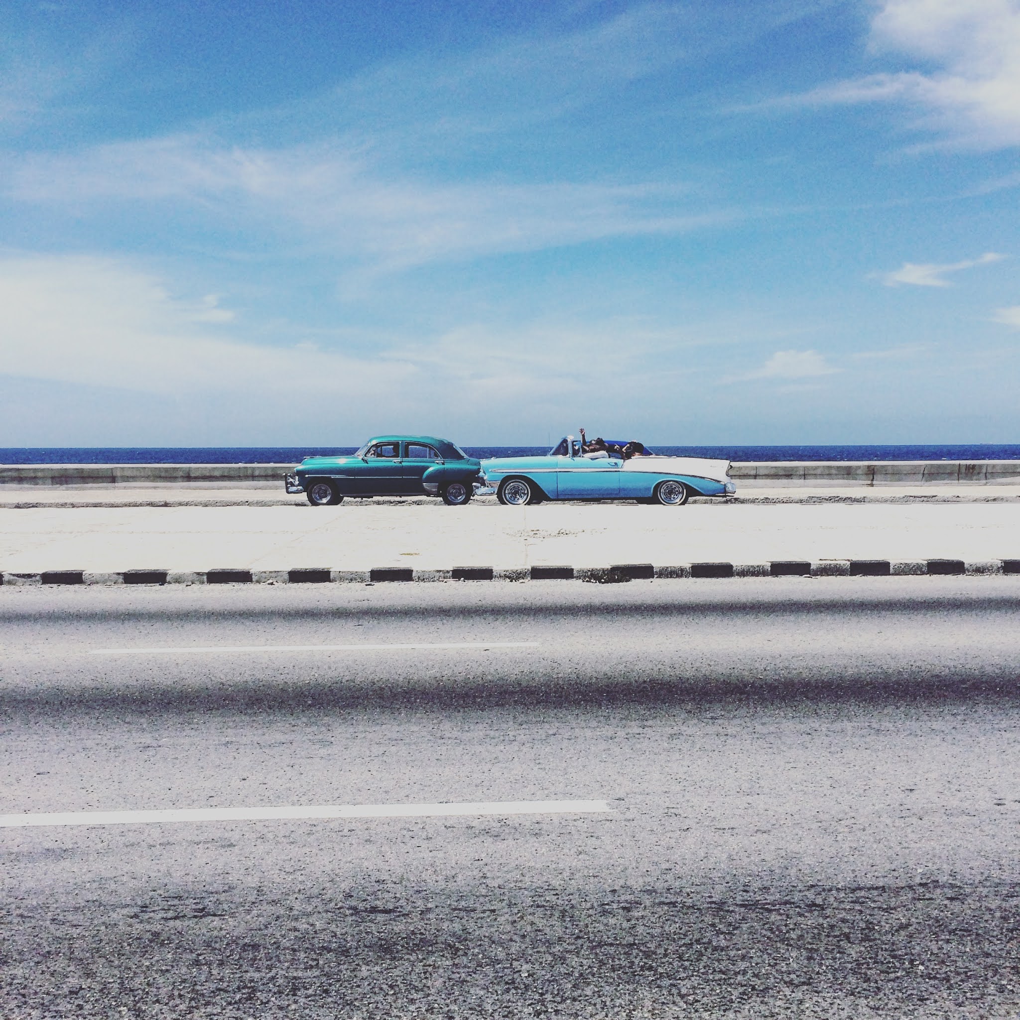 Vintage cars driving along Havana's sea front