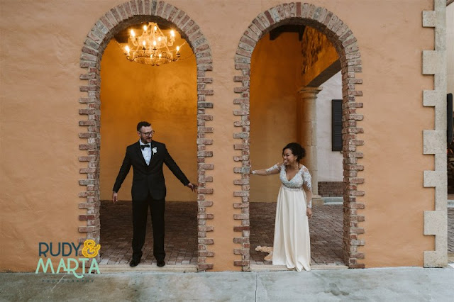 bride and groom standing in columns looking at each other