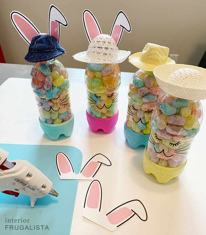 Easter bunny bottle craft with hats and white cardstock bunny ears.