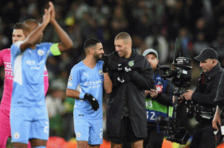 Des joueurs de Man city qui parlent et marchent sur le terrain de football