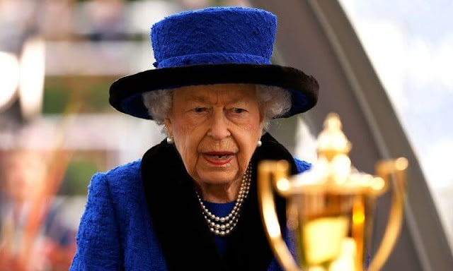 Queen is wearing her vibrant outfit with a typically stylish bag, a pearl necklace and matching earrings, as well as a silver brooch