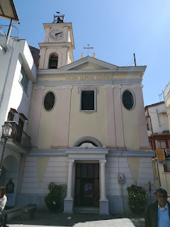 The church, with its pink and green façade, is set in its own square
