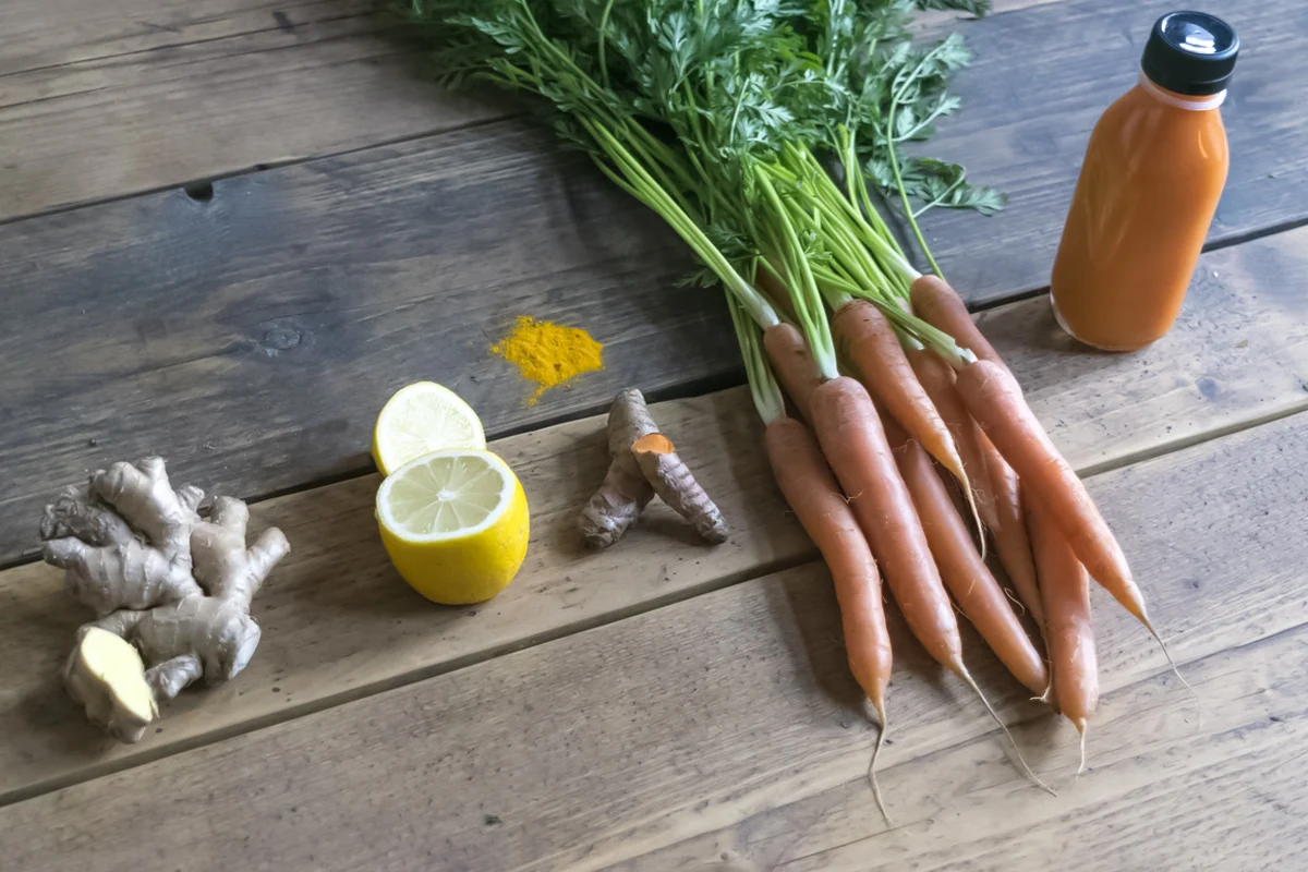 ginger, lemon, carrot, and juice on a table