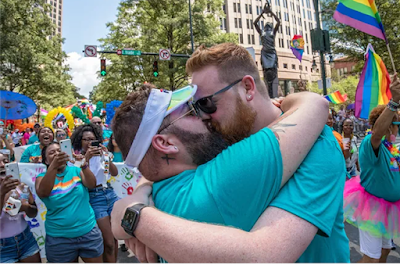 Justin Colasacco and his husband Bren Hipp kissing after Colasacco dropped to one knee and proposed in front of the crowd at the 2019 Charlotte Pride Festival & Parade.