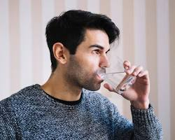 Apretar la nariz y beber agua para quitar el hipo
