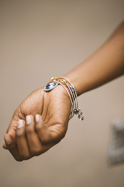 A close up of a person's hand and arm while wearing a bracelet.