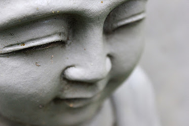 a sculpture of the face of a meditating monk