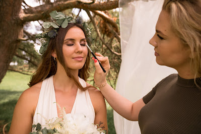 Maquilladora finalizando el maquillaje de una novia