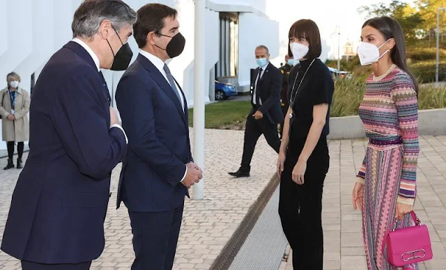 Queen Letizia wore a new ethnic gold stripe dress by Michonet. Carolina Herrera red pumps. pink shoulder bag