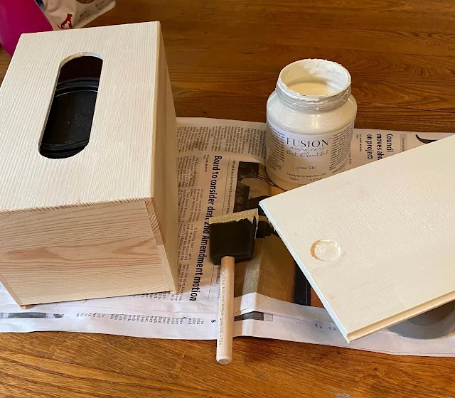 Photo of a wooden tissue box holder being painted with Fusion Mineral Paint in Raw Silk.