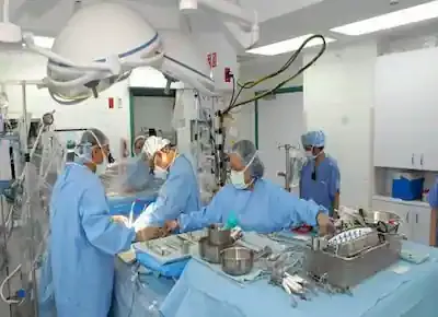 الأطباء والممرضات في غرفة العمليات الجراحية أثناء جراحة لأحد المرضى