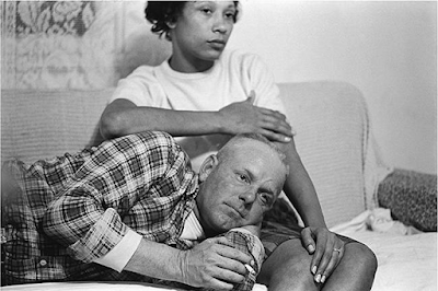 Black and white photography by Grey Villet of Mildred Loving, African-American and Native woman, with her white husband's head resting in her lap in 1965