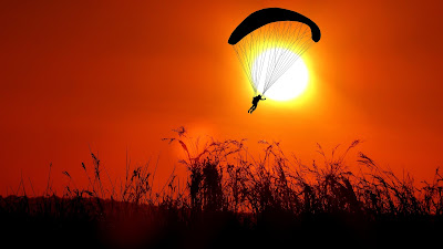 A parachutist against a sunset.