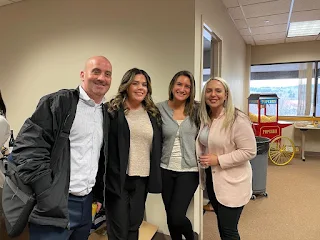 four employees standing together at happy hour