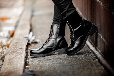 A Person Wearing Glossy Black Leather Boots