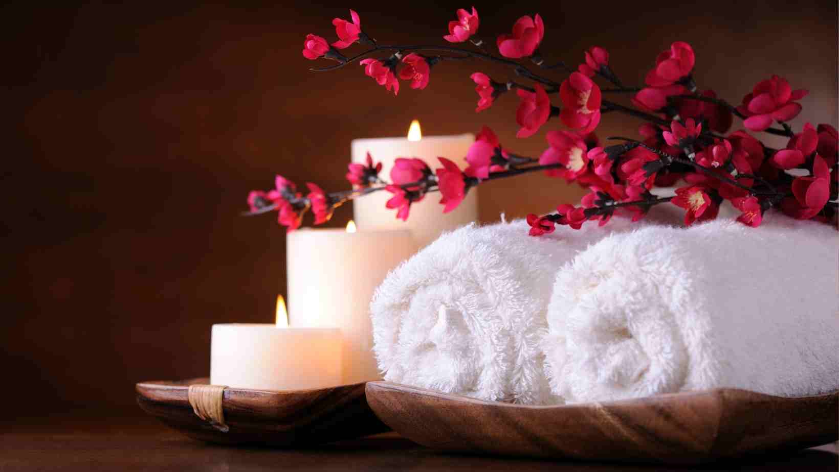 A stock image from Canva showing towels and a candle representing a relaxing spa break in Essex