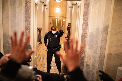 Capitol Police Officer Eugene Goodman stands firm as rioters push toward the Senate chamber during the Jan. 6 siege in the United States Capitol