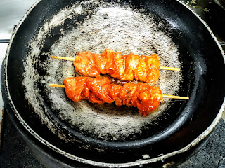 Two sticks of chicken Angara kabab on tawa