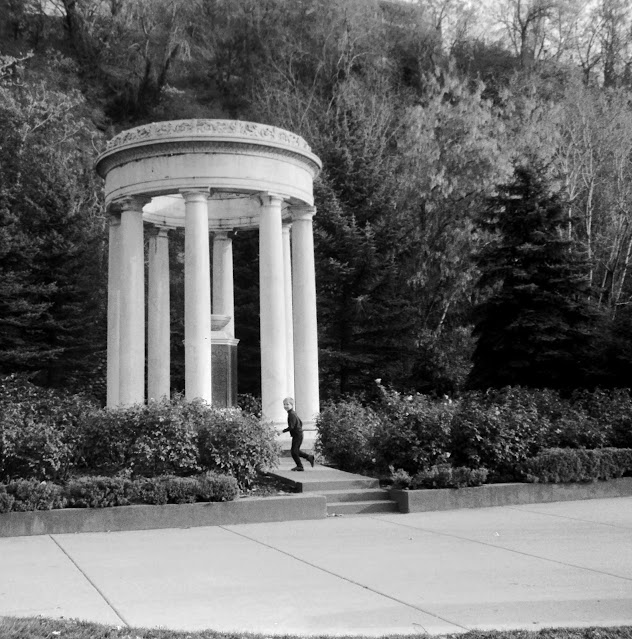 A small boy in front of a monument with columns